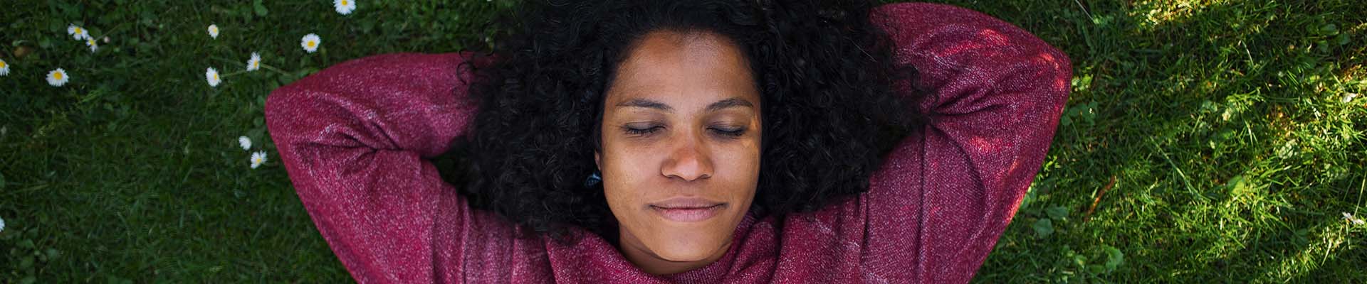 Woman lying on grass, eyes closed