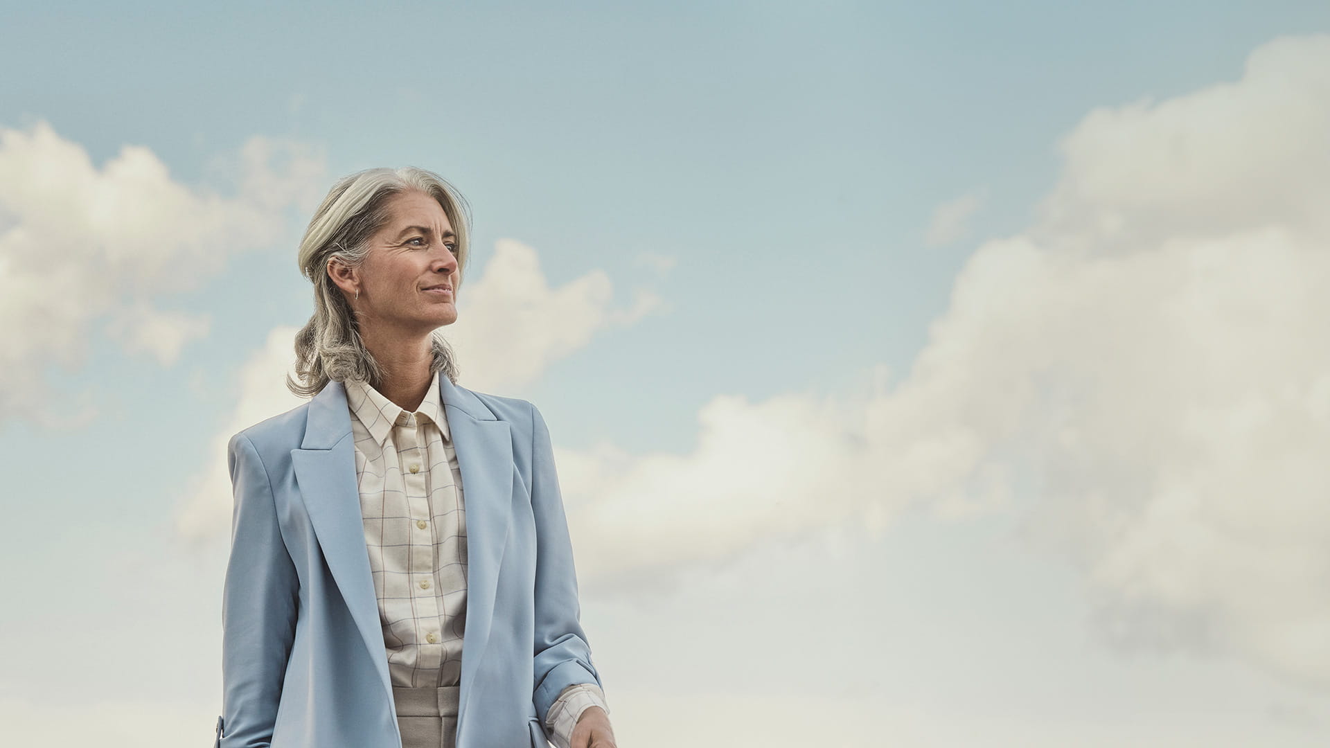 Woman in blue blazer in front of a skyline